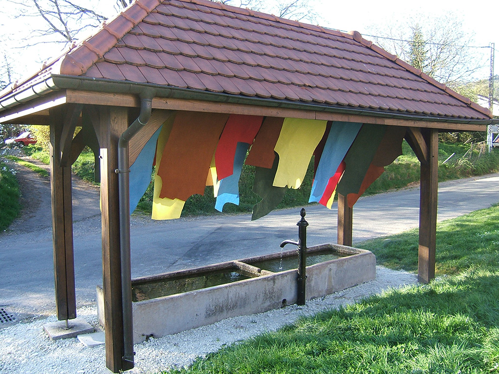 Installation de tissus colorés dans un lavoir.