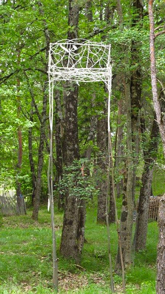Dans les bois, une installation en hauteur faite de branchages et de plumes.