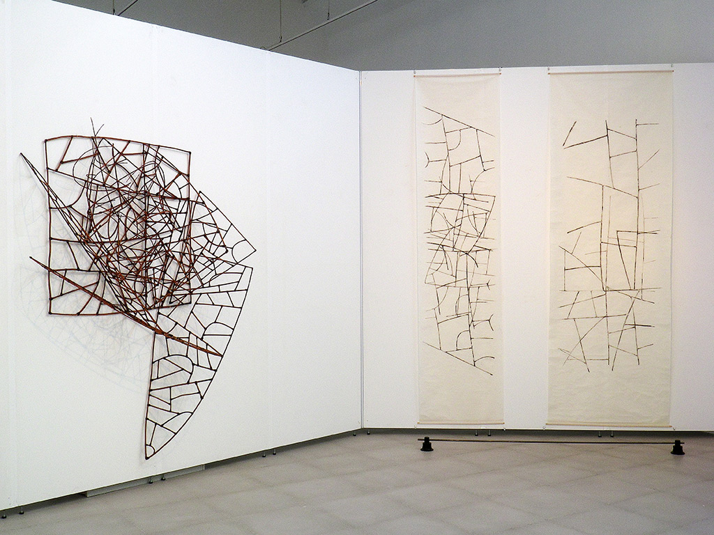 Plusieurs oeuvres d'Anne Mangeot, sculpture et estampes, sont accrochées sur un mur blanc pendant une exposition au musée de Villefranche.