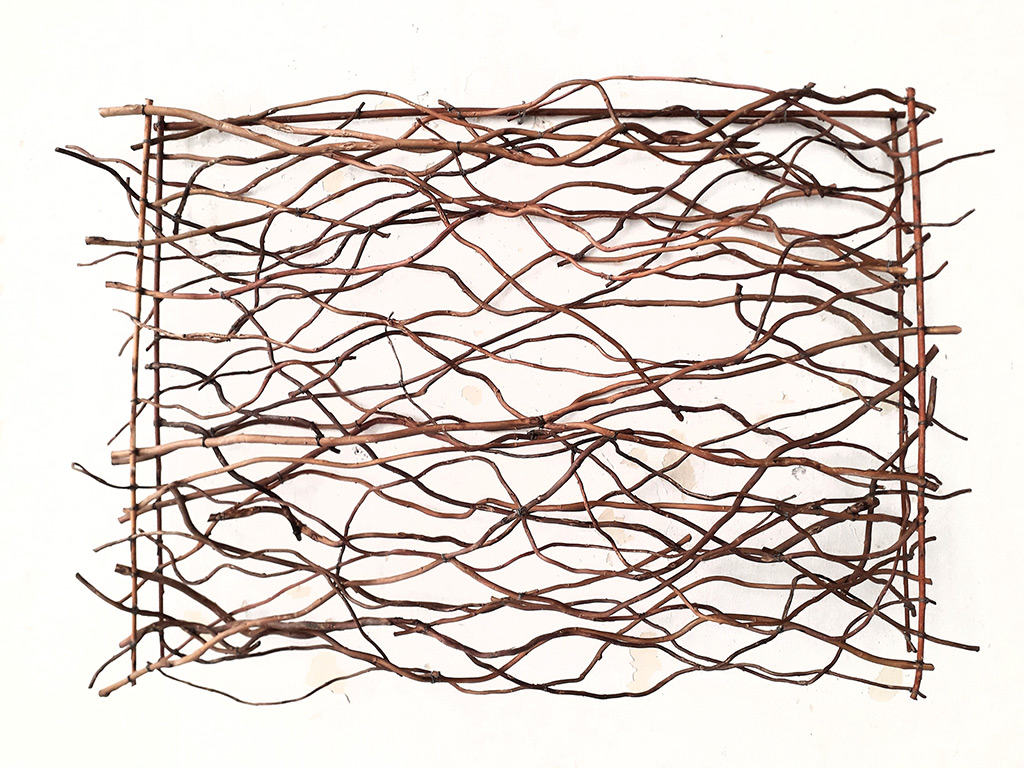 Sculpture d'Anne Mangeot sous forme de panneau mural avec des rythmes réalisé avec des branches graphiques tortueuses.