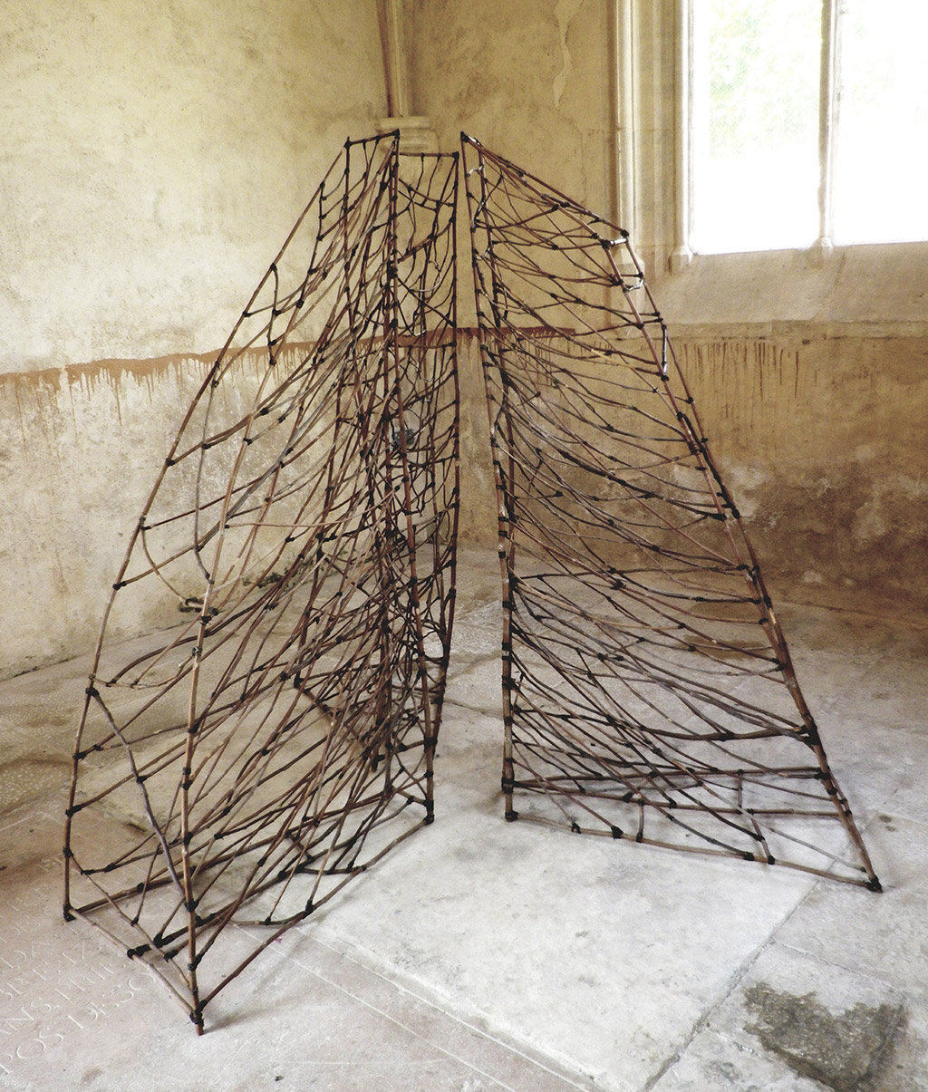 Sculpture réalisée en branchage par Anne Mangeot et exposée en intérieur.